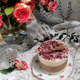 Large candle with white soy wax base topped with red rose petals