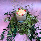 Large glass raspberry candle close-up showing red wax berry decorations in clear glass container