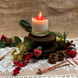 Large glass Winter Poinsettia candle top view with red poinsettia flower arrangement on white wax