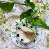 Small glass coffee bean candle burning with flame and coffee bean decoration in glass