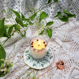 Small glass coffee bean candle burning showing gentle flame and glass container