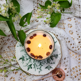Small glass coffee bean candle detail shot showing coffee beans embedded in glass container