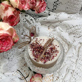Handcrafted small candle topped with crushed rose petals styled with vintage lace doilies and fresh pink roses
