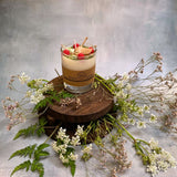 Small glass raspberry candle alternative angle displaying red wax berries in glass vessel