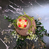 Small glass raspberry candle side view highlighting red berry decorations and glass container