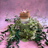 Small glass raspberry candle overhead shot displaying berry decorations in glass container