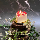 Small heart raspberry candle close-up highlighting red wax berry decorations and romantic heart shape