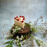 Small heart raspberry candle side view displaying heart shape with red berry decorative elements