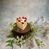 Small heart raspberry candle overhead shot displaying berry decorations and heart shape