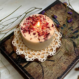 Burning Beauty Scents small rose petals candle with flame on wooden slice and lace doily with dried flowers