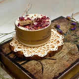 Handcrafted small candle topped with crushed rose petals styled on wood slice with vintage lace and purple dried flowers
