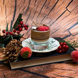 Small glass Winter Poinsettia candle close-up showing detailed corner decoration with red berries
