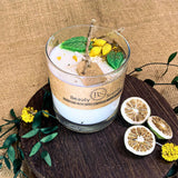 Glass candle with decorative elements on a wooden surface