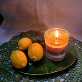Beauty Scents lemon scented candle burning on green plate with fresh lemons - handmade soy wax candle