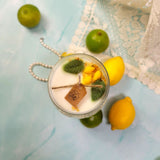 Handmade lemon scented soy candle with natural botanicals, fresh lemons and limes arranged on marble surface - Beauty Scents Candle