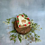 Large heart raspberry candle side view displaying heart shape with red berry decorative elements