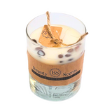 Small glass coffee bean candle with natural coffee beans decoration on clear background