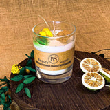 Candle in a glass jar with 'Beauty Scents' branding on a wooden surface with decorative elements.