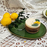 Beauty Scents small lemon candle with botanicals on green vintage plate with fresh lemons and white lace backdrop