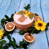 Beauty Scents small lemon candle with dried citrus slices and yellow flowers on blue wooden background