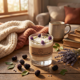 Candle with blackberries and lavender on a wooden surface with a cozy background