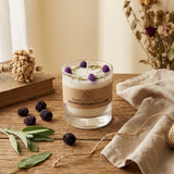 Glass candle with decorative elements on a wooden surface