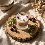 Candle in a glass jar with decorative elements on a wooden coaster