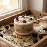 Candle with blackberries and herbs on a wooden tray, featuring 'Beauty Scents' branding.