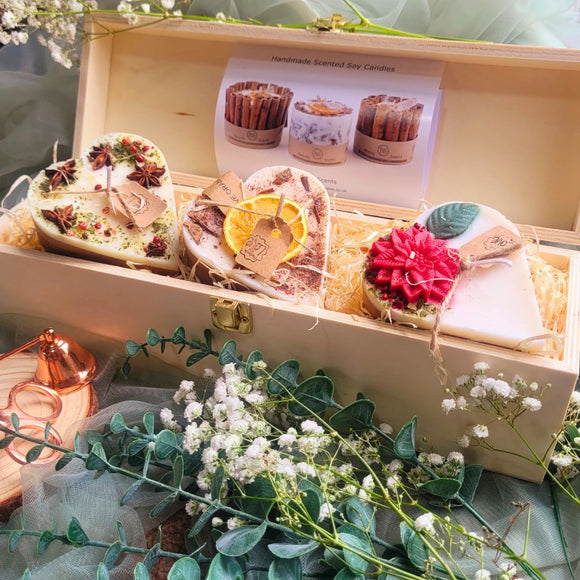 3 Hearts Winter Gift Set wooden box open view showing three heart-shaped candles with winter botanical decorations nestled in natural wood shavings