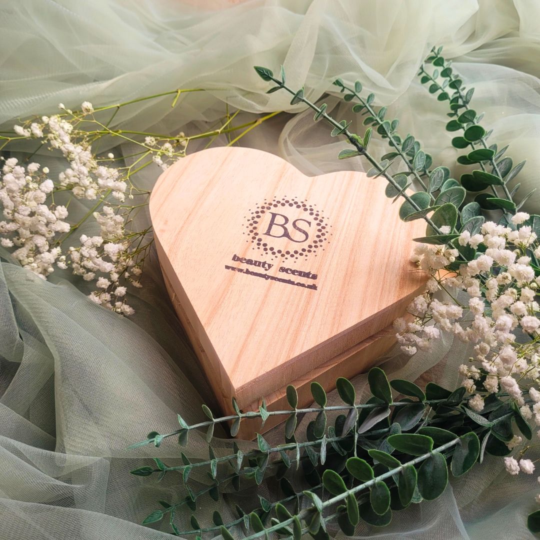 Empty heart-shaped gift box on green background showing elegant packaging design for winter candle gift set