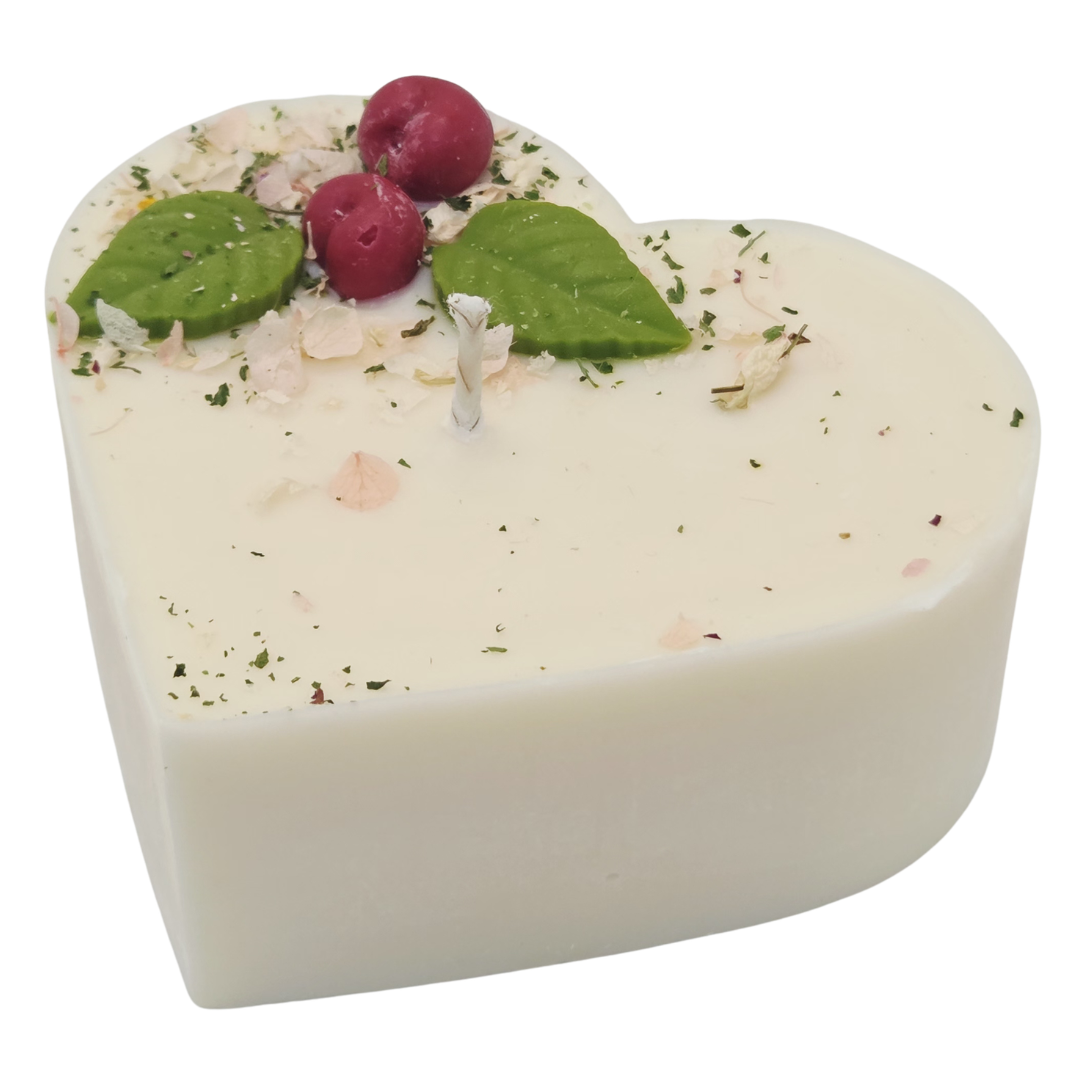 Heart-shaped candle with wax cherries green leaf on a white background