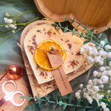 Large heart orange and cinnamon candle in elegant wooden heart-shaped gift box showing premium romantic packaging
