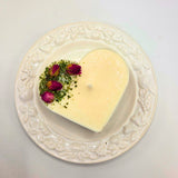 Heart-shaped candle with floral decorations on a decorative plate
