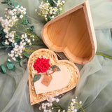 Heart Gift Box open view showing large heart-shaped hollyberry candle with red poinsettia flower and natural wood shavings
