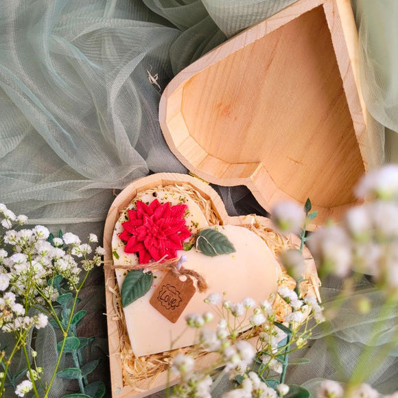 Large heart-shaped hollyberry scented candle with red poinsettia flower decoration in elegant wooden heart gift box