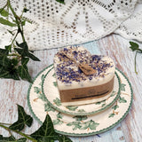 Large Heart Wild Flowers soy candle 500g with blue cornflowers decoration and Beauty Scents label on ivy-patterned plate, styled with fresh ivy leaves and white lace - heart-shaped rustic botanical lifestyle photography