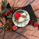 Large glass Winter Poinsettia candle angle view displaying handcrafted soy wax in glass container