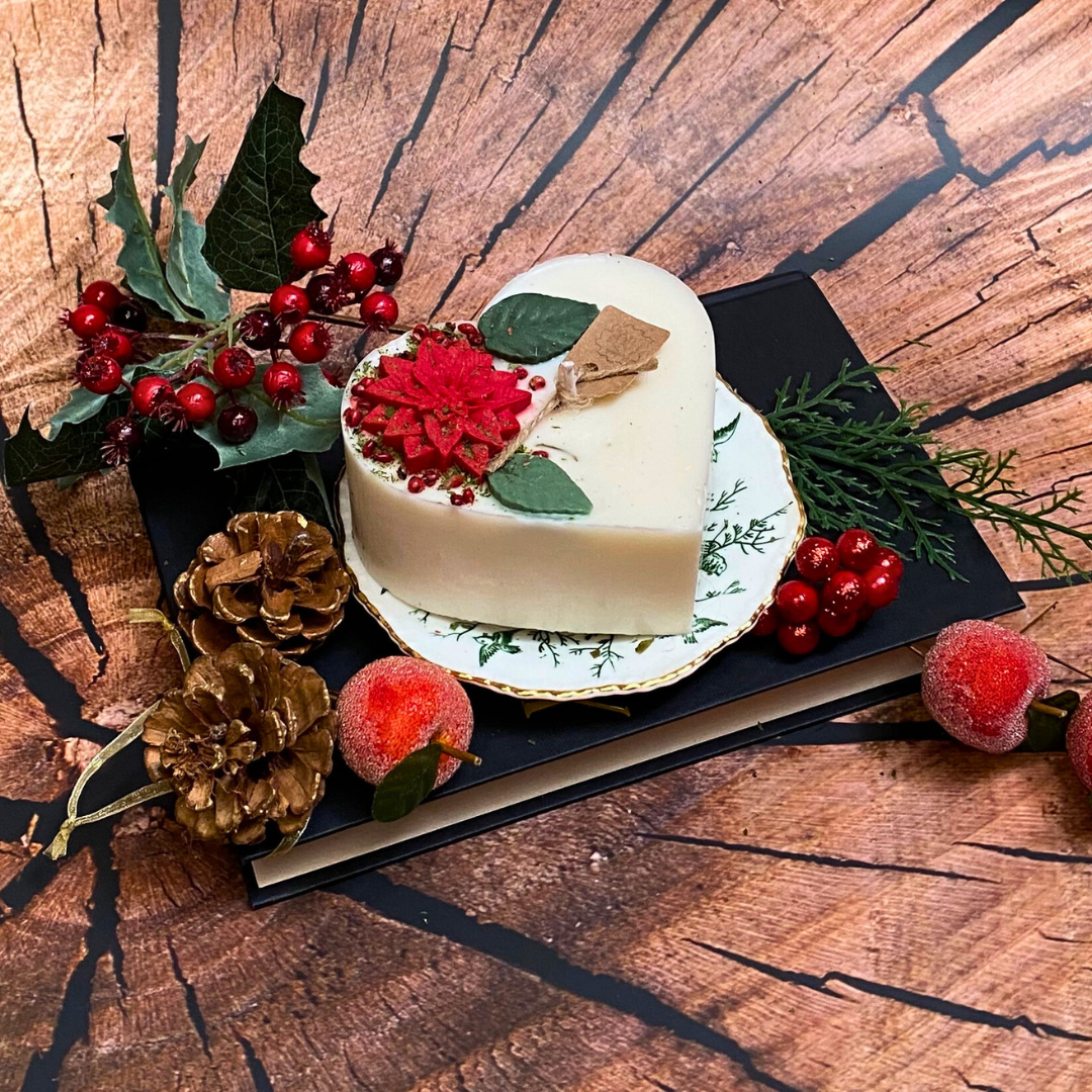 Large heart Winter Poinsettia candle close-up showing detailed corner decoration with red berries