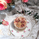Medium artisan candle with rose petals on beautiful vintage floral plate with lace and fresh flowers