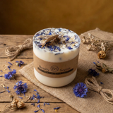 Beauty Scents medium wildflower candle in a glass jar, decorated with blue petals, styled with natural twine and dried botanicals.
