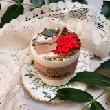 Medium Winter Poinsettia candle angle view showing corner decoration with green leaves and red berries