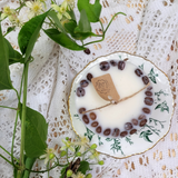 Small coffee candle from above displaying coffee beans arranged around edges and center