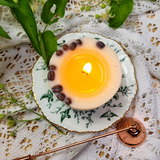 Small coffee candle burning steadily on plate creating intimate dining atmosphere