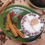 Beauty Scents small coffee candle featuring coffee bean decoration displayed on green plate with festive cinnamon and berry styling