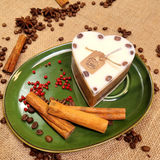 Side view of small heart coffee bean candle showing natural coffee beans embedded in wax