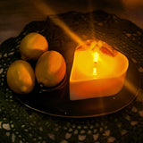Heart-shaped candle with lemons on a textured surface