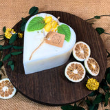 Heart-shaped candle with decorative elements on a wooden board