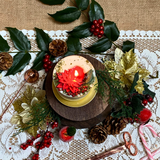 Small Winter Poinsettia candle lifestyle shot with Christmas décor styling and Hollyberry scent