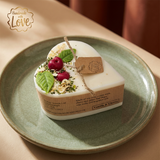 Small heart-shaped soy candle with cherry wax melt decoration and green leaf detail on a green ceramic plate, with tag and Vanilla & Cherry label.