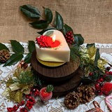 Small heart Winter Poinsettia candle top view showing white wax with festive botanical decoration